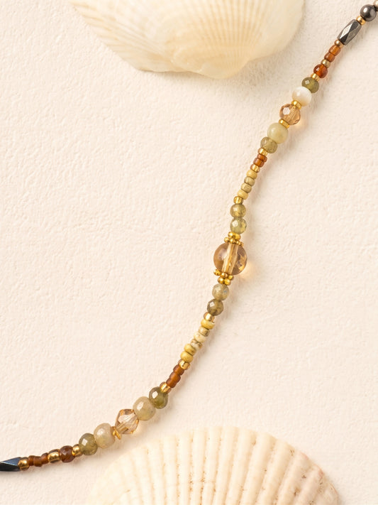 Détail des perles fines en cristal aux tons vert olive et sable du collier SOUS LES OLIVIERS.