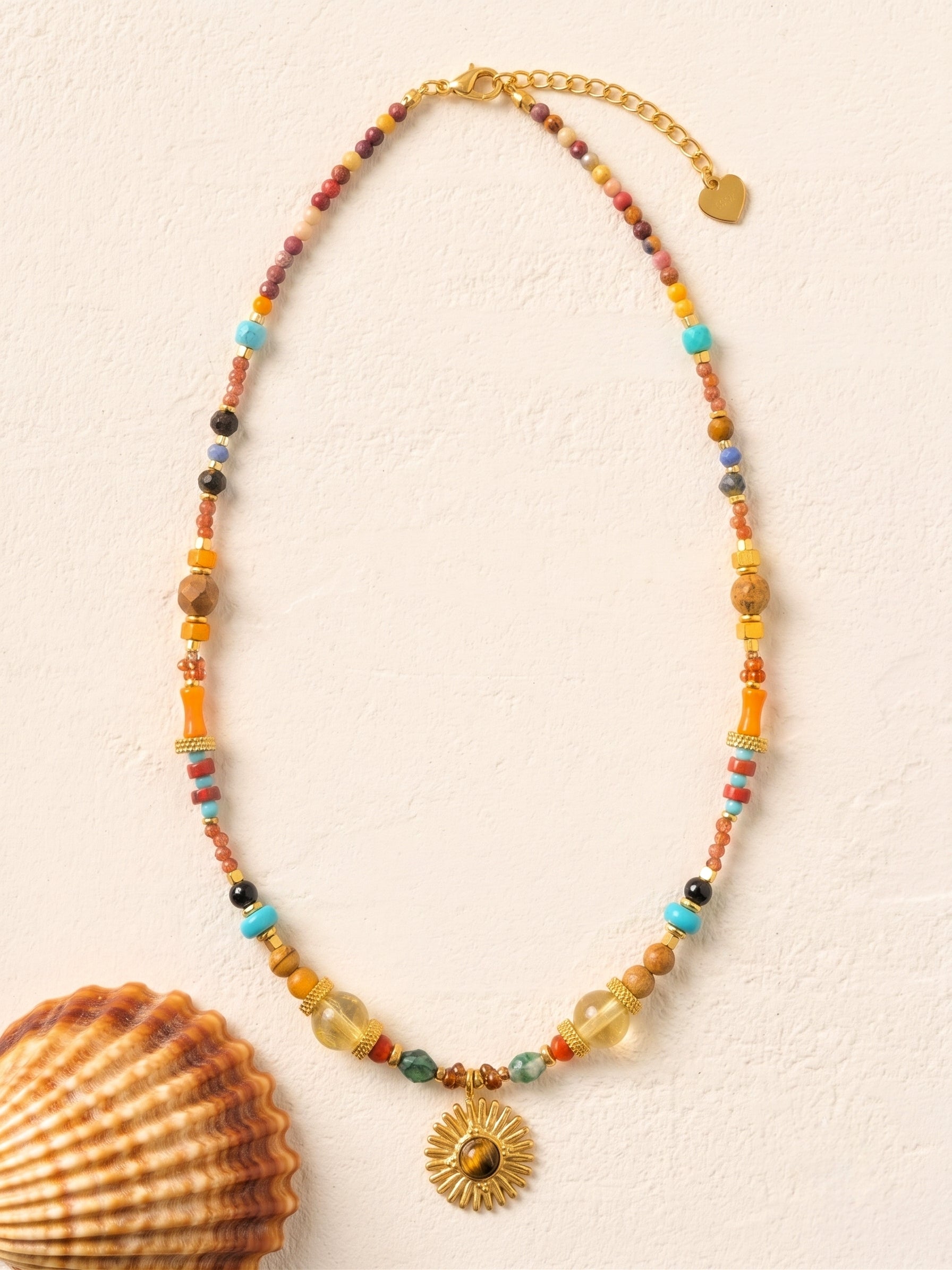 Le collier DUNE DORÉE est une véritable ode au soleil. Ras de cou en pierres naturelles et pendentif soleil, conçu en acier doré inoxydable pour vous accompagner partout, même à la plage (waterproof). 🛍️ Cliquez pour l'offrir ou vous faire plaisir !